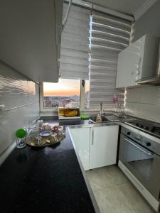 uma cozinha com armários brancos e um balcão com comida em SN Apartment city center em Shkodër