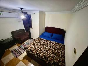 Jessy`s Hotel في القاهرة: غرفة نوم صغيرة بها سرير وكرسي