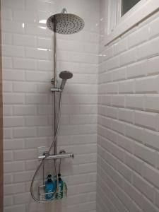 La salle de bains est pourvue d'une douche et de carrelage blanc. dans l'établissement Vacacional muelle alto A Guarda, à A Guarda