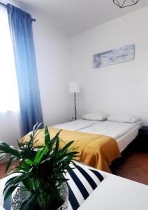 1 dormitorio con 1 cama y una maceta en Przy Plaży en Karwia