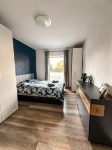 a bedroom with a bed and a large window at Apartament Wierzbowy in Jelenia Góra