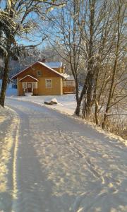 uma estrada coberta de neve que leva a uma casa em Vackert och fridfullt i jordhus, 90 kvm em Nyköping