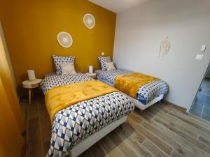 two beds in a room with yellow walls at Les bambous - 2 logements 10min du zoo neuf-confort-famille-jeux pour enfants in Saint-Romain-sur-Cher