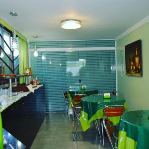 a restaurant with green tables and chairs in a room at Hospedagem Belo Horizonte in Macaé