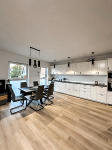 a large kitchen with a dining table and chairs at Apartament Wierzbowy in Jelenia Góra