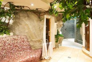ein Wohnzimmer mit einem Sofa und einer Steinmauer in der Unterkunft Hotel Silvretta in Sankt Gallenkirch