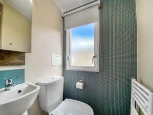 a bathroom with a toilet and a sink and a window at Brookwood in Weston-super-Mare