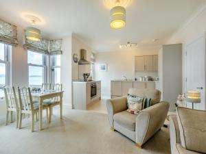 a living room with a table and chairs and a kitchen at Poppin-uk47165 in Brixham