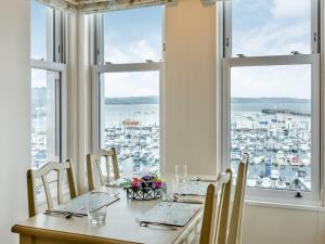 a table in a room with a view of a harbor at Poppin-uk47165 in Brixham