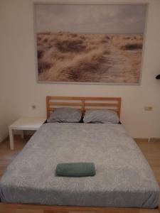 Una cama con una almohada verde encima. en Viola Apartments Brussel Stay en Bruselas