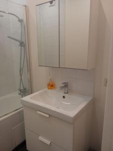 Baño blanco con lavabo y espejo en Viola Apartments Brussel Stay en Bruselas