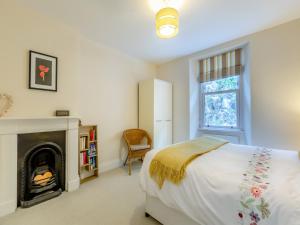 a bedroom with a bed and a fireplace at Poppin-uk47165 in Brixham