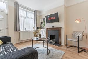 a living room with a couch and a fireplace at Modern 3 bedroom house with free parking in Leicester