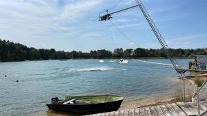 a boat is docked on a lake with a crane at Modernes Privathaus am See mit Highspeed-Internet in Sassenburg