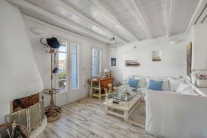 a living room with a white couch and a fireplace at Samanti House, Leivadi Serifos in Livadi
