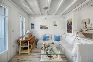 a living room with a white couch and a table at Samanti House, Leivadi Serifos in Livadi