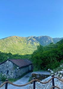 un edificio de piedra con una montaña en el fondo en Skadar Lake Aparment Nikola II en Virpazar