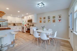 a kitchen with white cabinets and a table and chairs at Modern Urbana Home 2 Mi to University of Illinois in Urbana