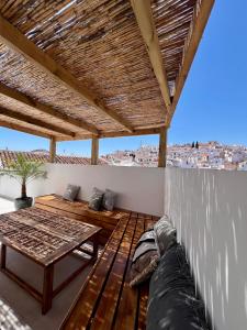 un patio con sofá y una mesa en el techo en Renovated cinema town house in Comares, en Málaga