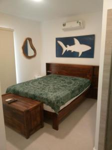 a bedroom with a wooden bed and a fish painting on the wall at Villa Country Club Salinas in Salinas