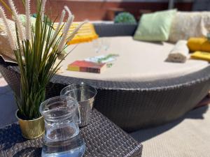 un tavolo con un bicchiere d'acqua su un tavolo con un divano di Hevres El Capricho a Málaga