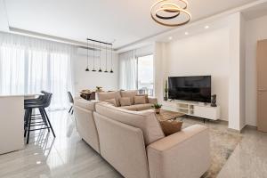 - un salon avec un canapé et une télévision dans l'établissement YAMAS Urban Living Pool Penthouse Marvel, à Limassol