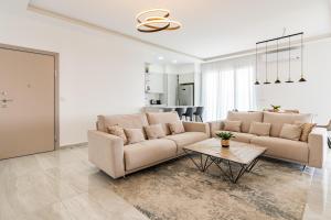 een woonkamer met 2 banken en een tafel bij YAMAS Urban Living Pool Penthouse Marvel in Limassol