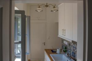 a kitchen with white cabinets and a sink at Blue Coral Hydra in Hydra