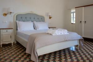 een slaapkamer met een bed met twee handdoeken erop bij Blue Coral Hydra in Hydra