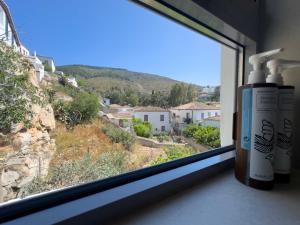 a window with two bottles of hair products on a window sill at Blue Coral Hydra in Hydra