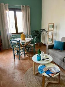 een woonkamer met een tafel en stoelen en een bank bij Rif Holiday Home Stagnone Marsala in Birgi Vecchi