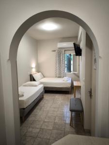 a room with two beds and a window and an archway at Maro's Apartments in Argostoli