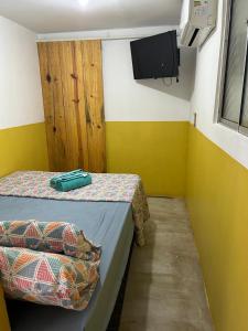 um quarto com duas camas e uma televisão na parede em Tiny Lagoa em Jiloca de Jericoacoara