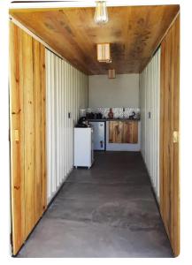 a hallway of a kitchen with a white refrigerator at Tiny Lagoa in Jijoca de Jericoacoara