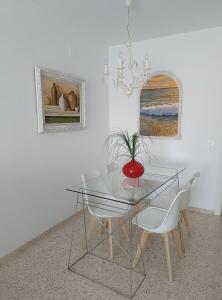 uma sala de jantar com uma mesa de vidro e 2 cadeiras em Mirador Bajo de Guía em Sanlúcar de Barrameda