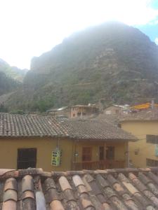 una montaña en el fondo de un pueblo con techos en Hostal festival, en Ollantaytambo