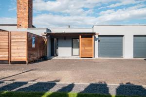 een huis met twee garagedeuren en een bakstenen gebouw bij Pracownia Pod Kominem in Poznań