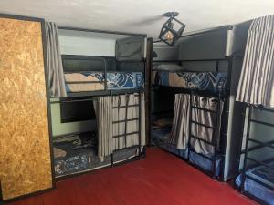a room with three bunk beds and a doorway at Aguaymanto pisac hostel in Pisac