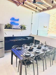 Hospedagem Triplex Vista Beira Mar 7 Estrelas Patacho في بورتو دي بيدراس: غرفة طعام مع طاولة مع كراسي ومطبخ