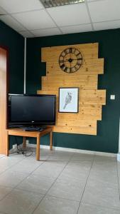 a room with a tv and a clock on a wall at Ferienhaus mit Seeblick in Templin