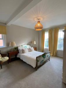 a bedroom with a large bed and a chandelier at Beach House in Swanage +27 photos