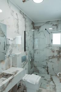La salle de bains est pourvue d'une douche, de toilettes et d'un lavabo. dans l'établissement In Town Boutique HOTEL, à Pristina