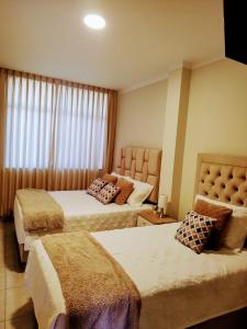 una camera d'albergo con due letti e una finestra di SHUMAQ YUNGAY - Depas a Yungay