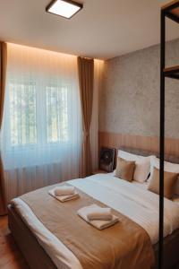 a bedroom with a large bed with two towels on it at In Town Boutique HOTEL in Pristina