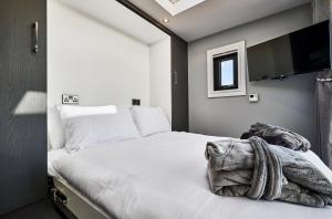 a bedroom with a white bed with a flat screen tv at Umry-Calm Farm Stays in Feeny