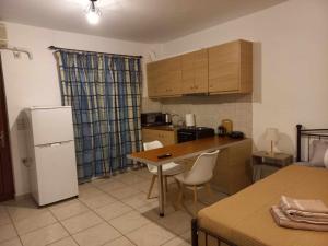a kitchen with a refrigerator and a table and chairs at Sophie's Sunny Spot 3 in Yéfira