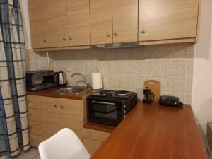 a small kitchen with a stove and a sink at Sophie's Sunny Spot 3 in Yéfira +8 photos