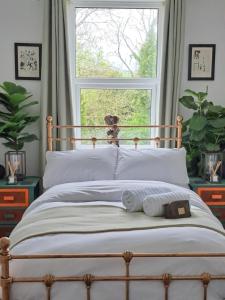 a bed with white pillows in front of a window at The cosy nook in Barnstaple