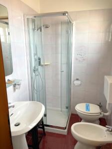 ein Bad mit einer Dusche, einem WC und einem Waschbecken in der Unterkunft Hotel Villa Augusta in Grado