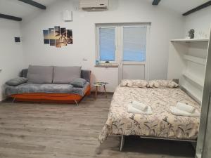 een woonkamer met twee bedden en een bank bij Apartma Vista Baredi in Izola +23 foto's